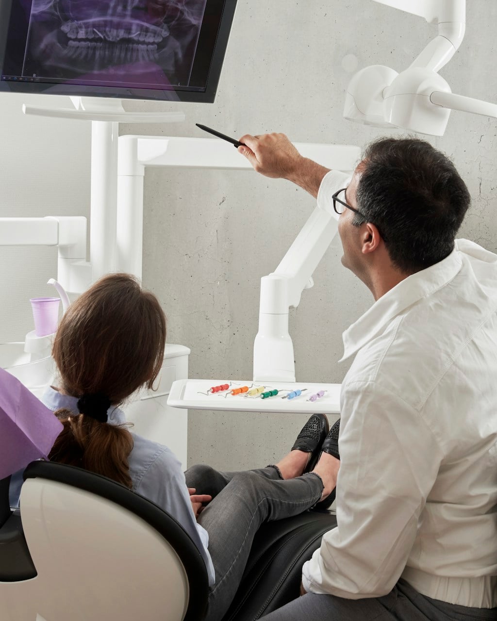 Dentist showing a dental X-ray to a patient at Almona Dental Clinic